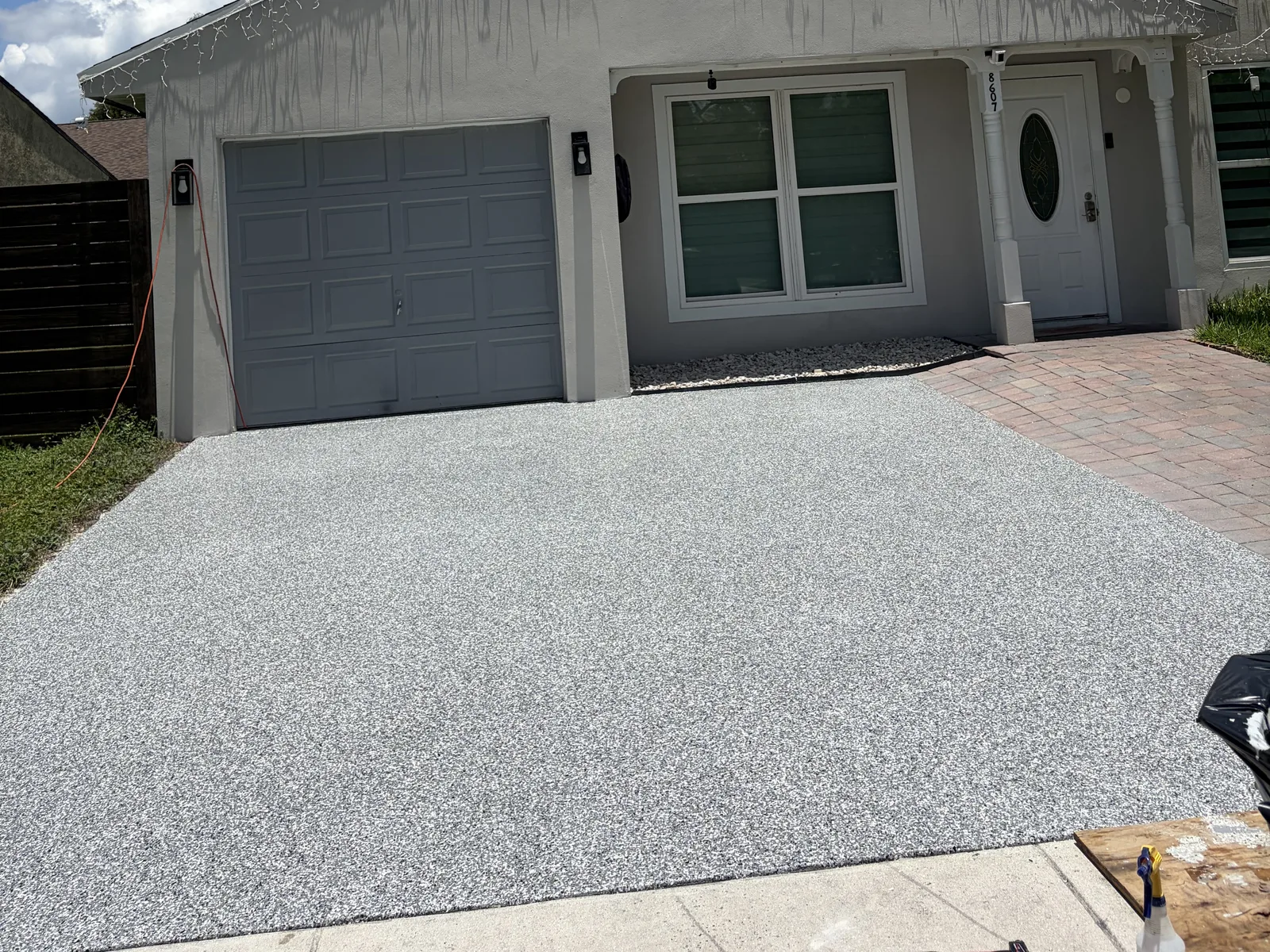 Finished gray, black, and white flake epoxy driveway